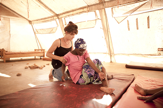 An MSF physiotherapist in Gitega, Burundi, works with Sandrine, 17, to help her build up enough muscle strength to undergo fistula repair surgery. She sustained a fistula, as well as nerve damage and other complications, due to a poorly performed episiotomy at another health facility.  Photo by Martina Bacigalupo