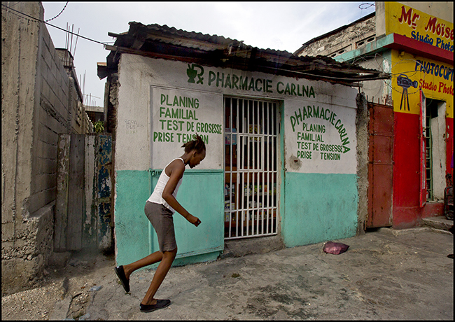 A young girl plays outside a typical pharmacy in downtown Port-au-Prince where misoprostol - a drug used to induce abortions - is readily available without prescription. Photo by Patrick Farrell
