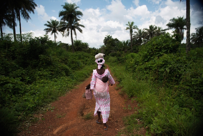 A mother walks back to her village after coming to the GRC to get her baby vaccinated. Photo by Lynsey Addario