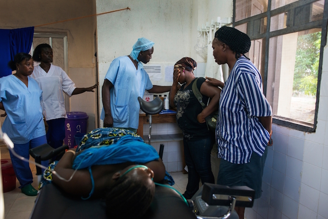 A third year medical student, lies in a coma. She was suffering from post-partum hemorrhage while she was delivering her baby at a government clinic outside of Freetown. She was sent to the MSF hospital for emergency care. Photo by Lynsey Addario