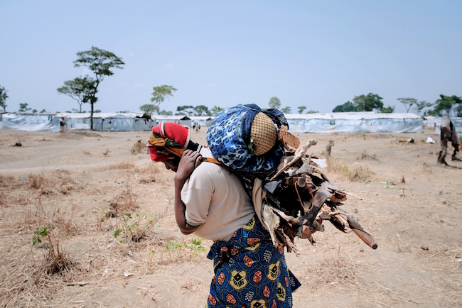 A Burundian woman carries firewood in Nyarugusu camp in Tanzania. Photo by Luca Sola