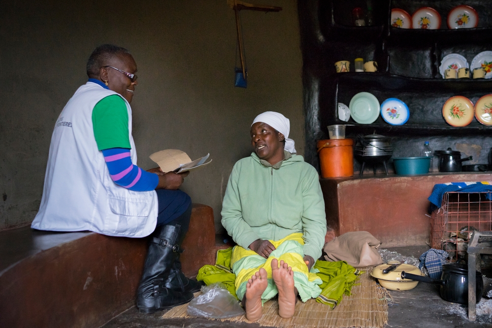 Tendai Chigurah a nurse mentor, visits, Florence at home in a remote village near Chimombe Hospital in Gutu district. Photo by Melanie Wenger/COSMOS